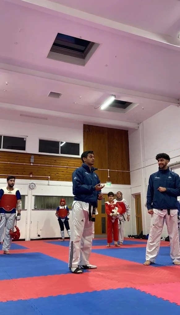 Head coach addressing students on the mat during class