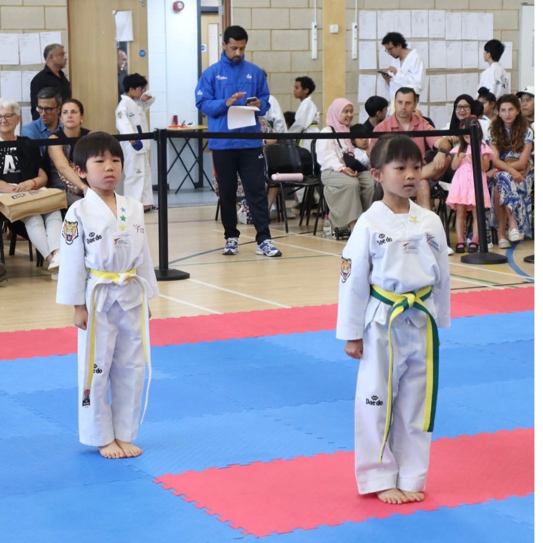 Little Panthers in white uniforms lined up at a belt grading